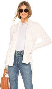 A woman wearing a white open front cardigan from REVOLVE.