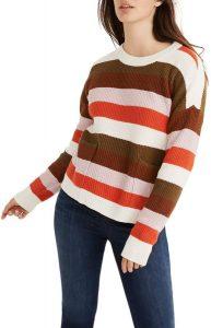 A woman wearing a striped patch pocket pullover sweater.
